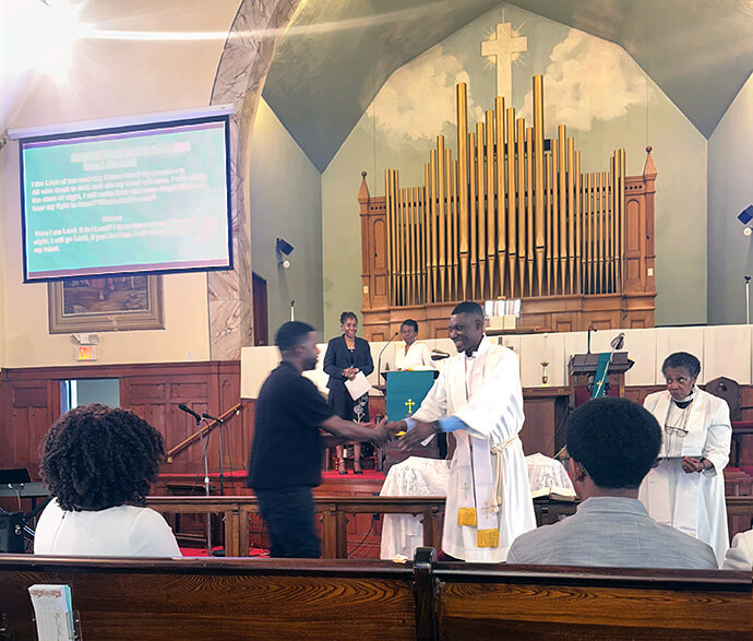 The Rev. Francis Lunge (center) greets a church member during his installation at Greenwood Memorial United Methodist Church in Dorchester, Mass., on Sept. 14, 2025. Lunge died Oct. 8 at age 41. Photo courtesy of Florence Lee. 